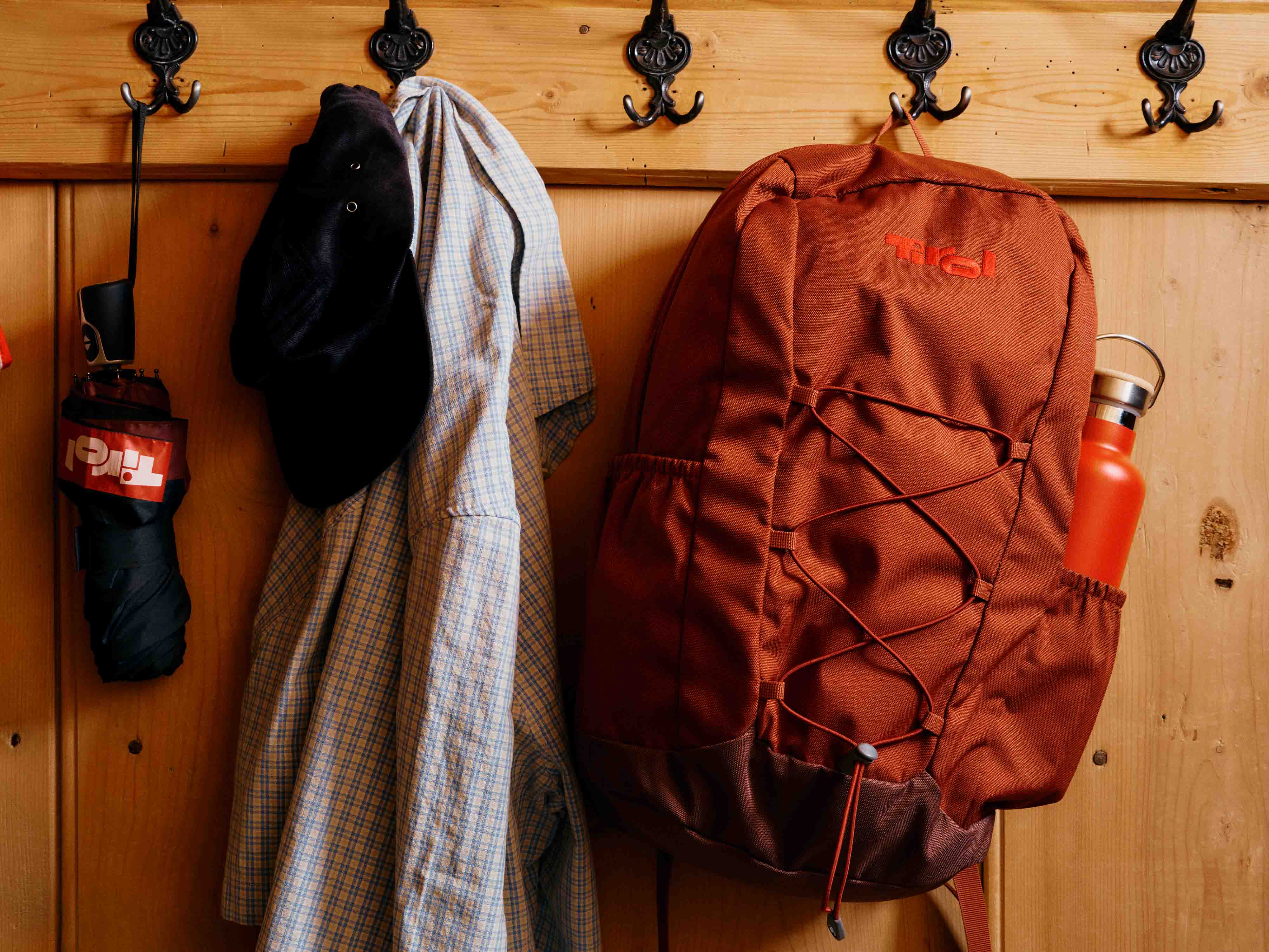 Roter Tirol-Rucksack vor einer Holzwand