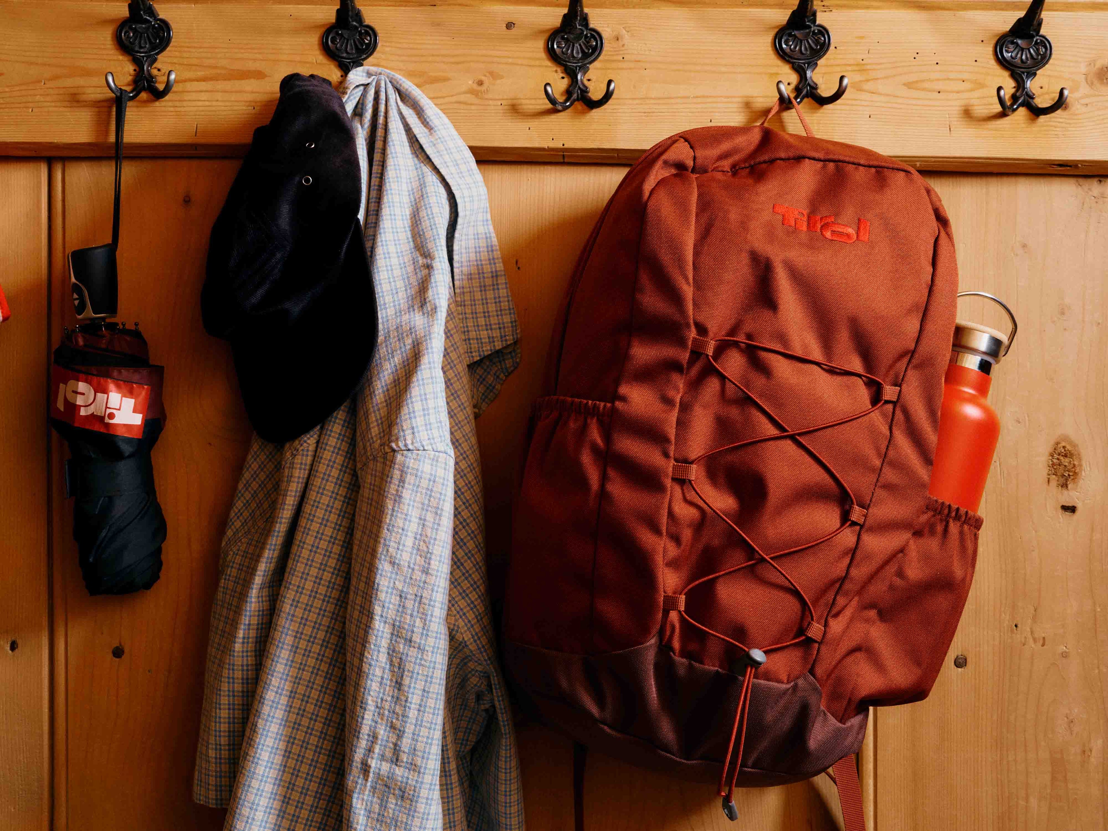 Roter Tirol-Rucksack vor einer Holzwand