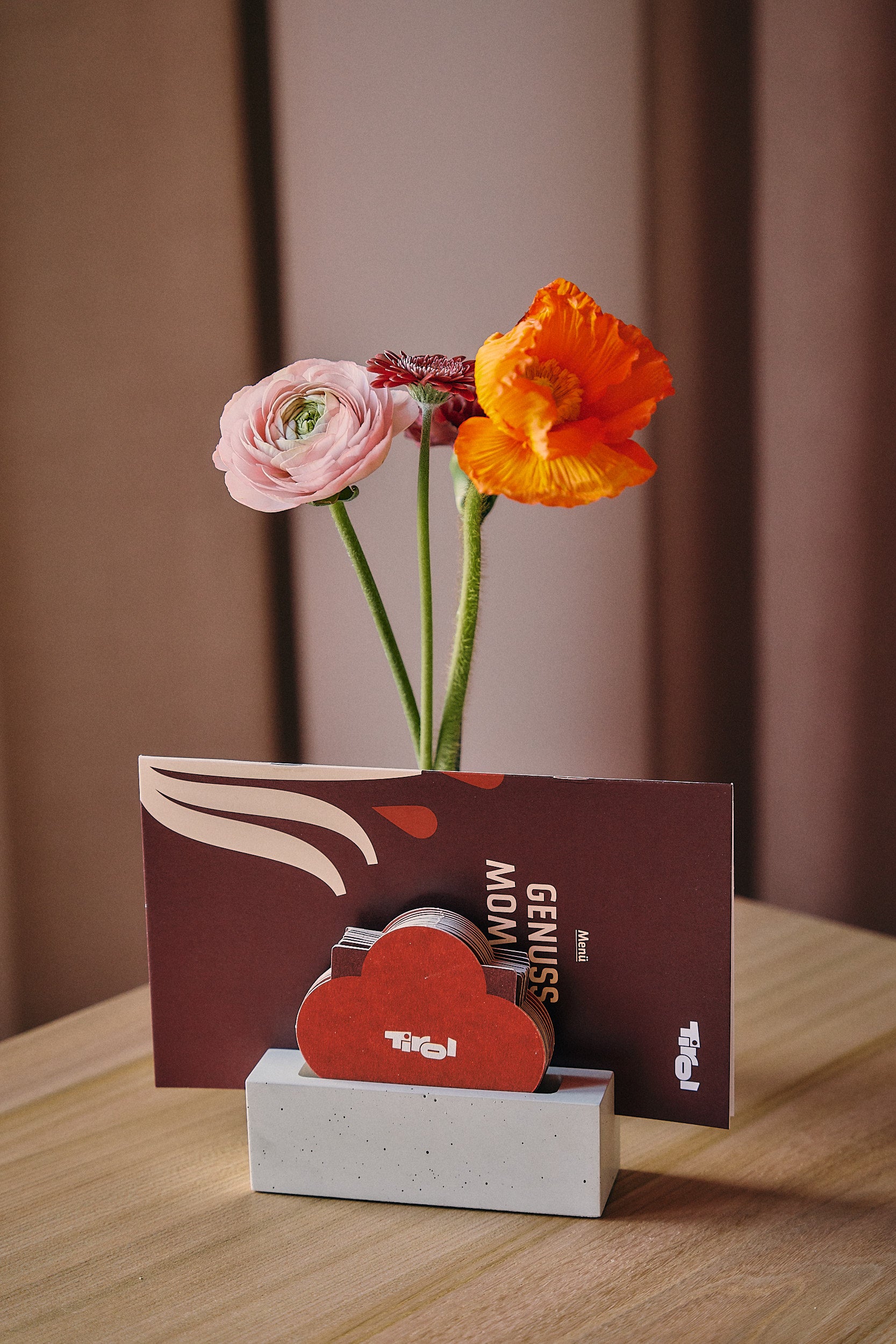 Tischdekoration mit Blumen und Speisekarte im Moments Tirol