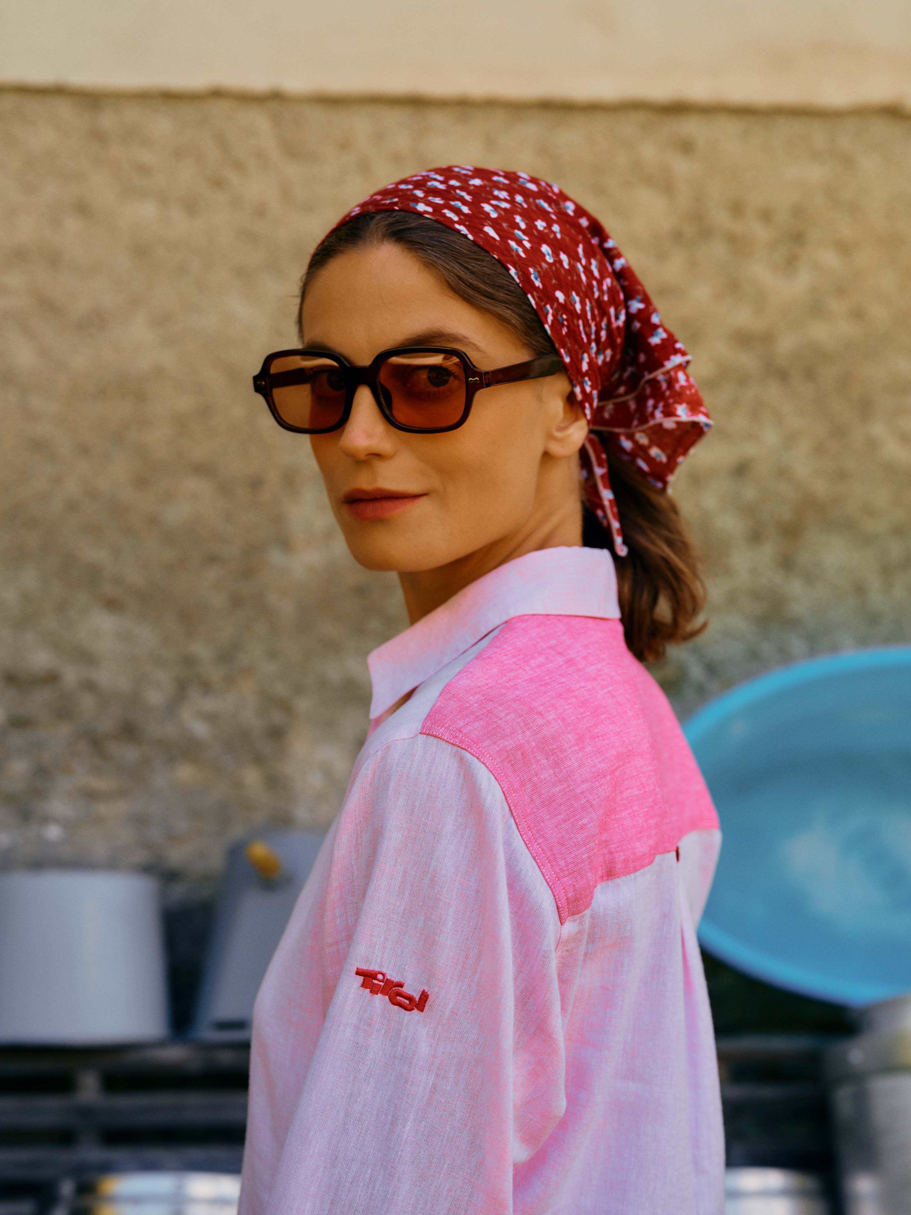 Eine Dame mit Sonnenbrille schaut über ihre Schulter und trägt die leichte Leinen-Bluse "Minou" in Rosa