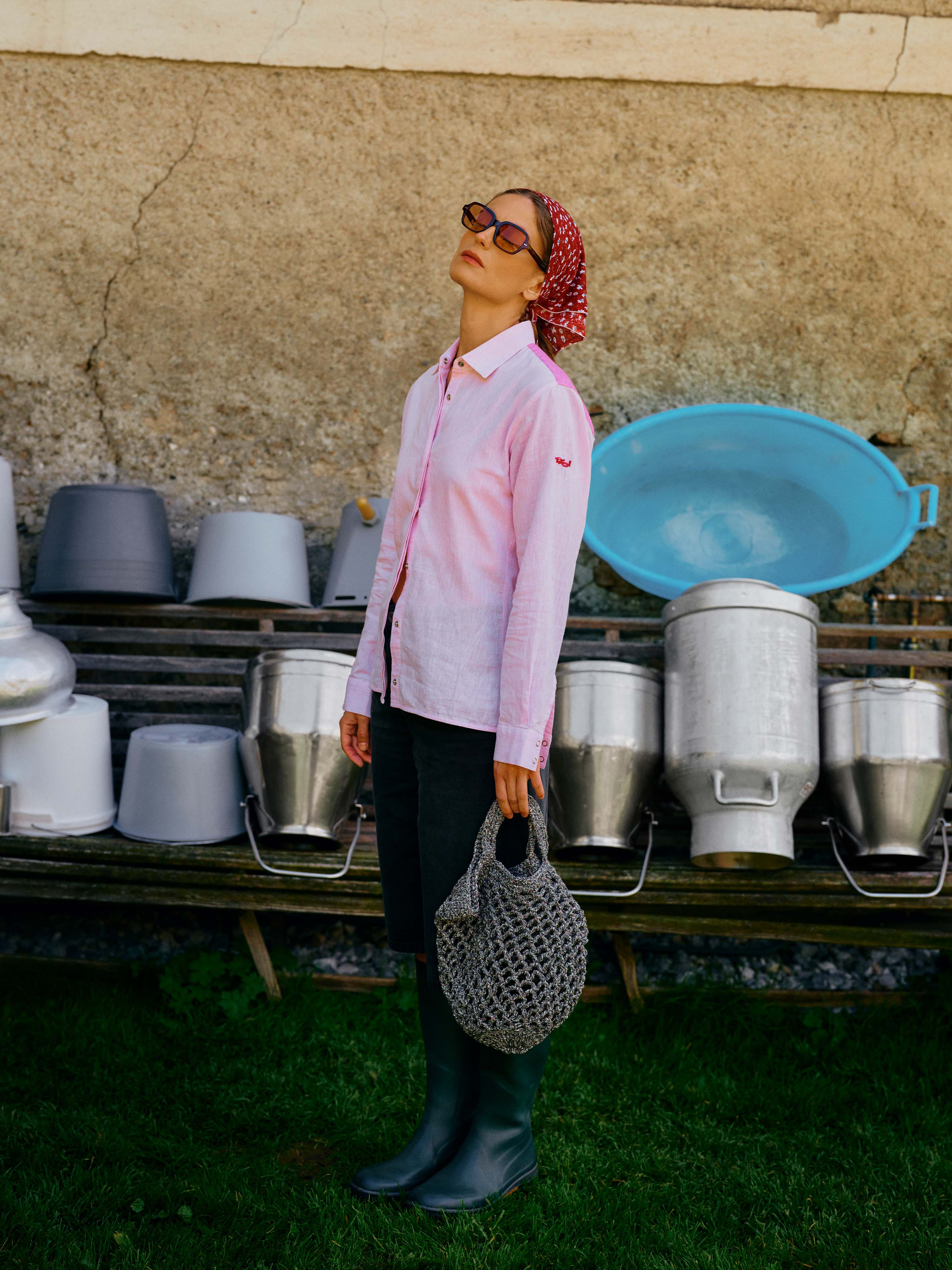 Eine Dame mit Sonnenbrille steht im Gras und genießt die Sonne. Sie trägt  die leichte Leinen-Bluse "Minou" in Rosa