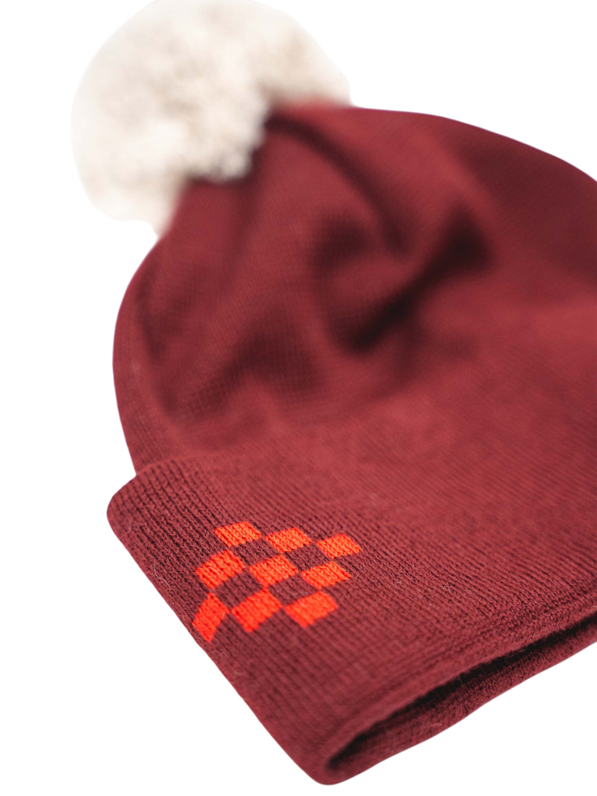 Strickmütze "Tanja" in Dunkelrot mit beigem Bommel und Tirol Traditionsmotiv auf der Stulpe
