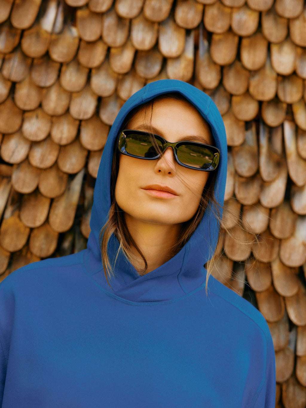 Der Unisex Hoodie "Noel" in der Farbe Navy und mit Kapuze getragen von einer Dame mit Sonnenbrille.