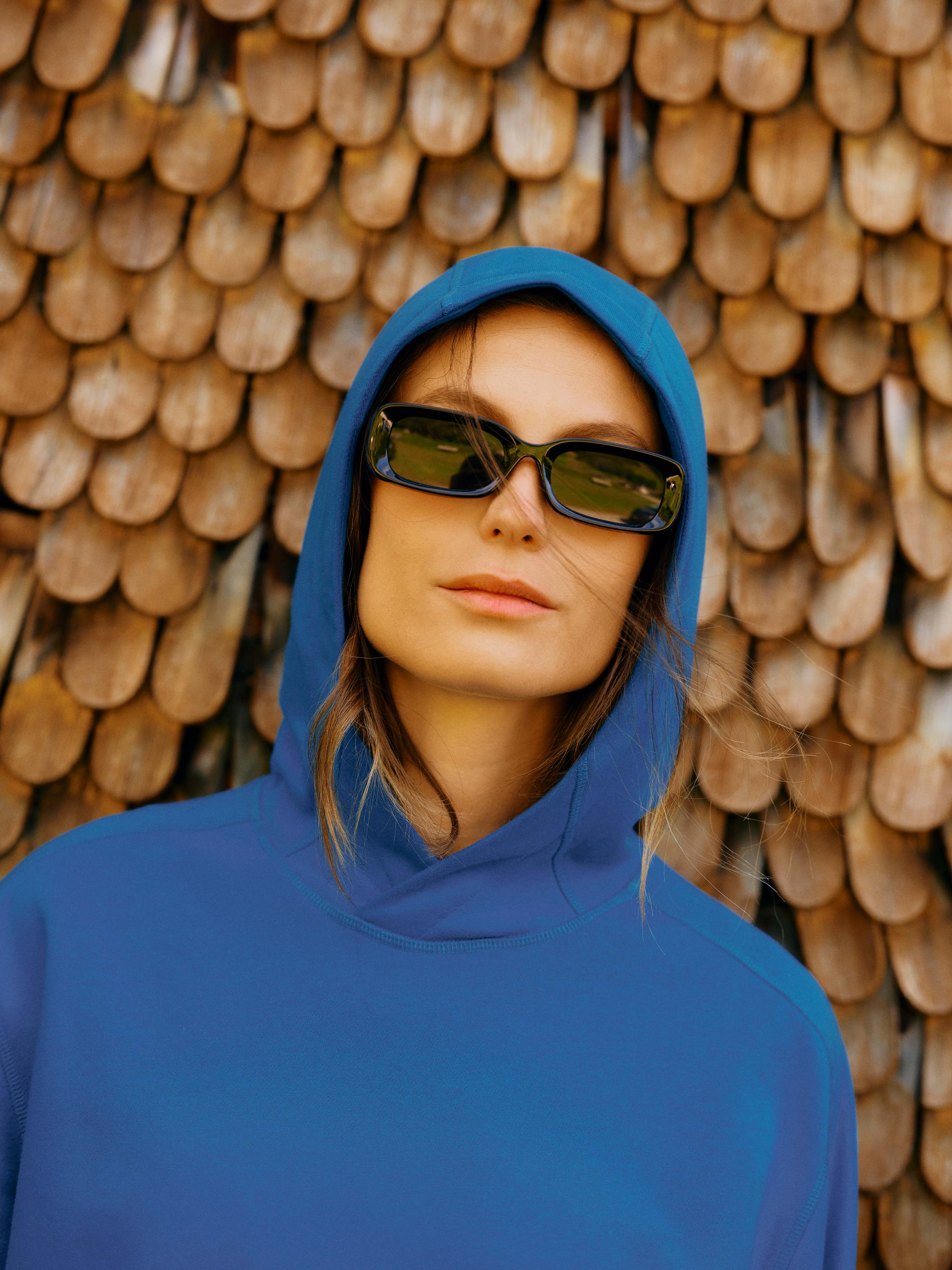 Der Unisex Hoodie "Noel" in der Farbe Navy und mit Kapuze getragen von einer Dame mit Sonnenbrille.