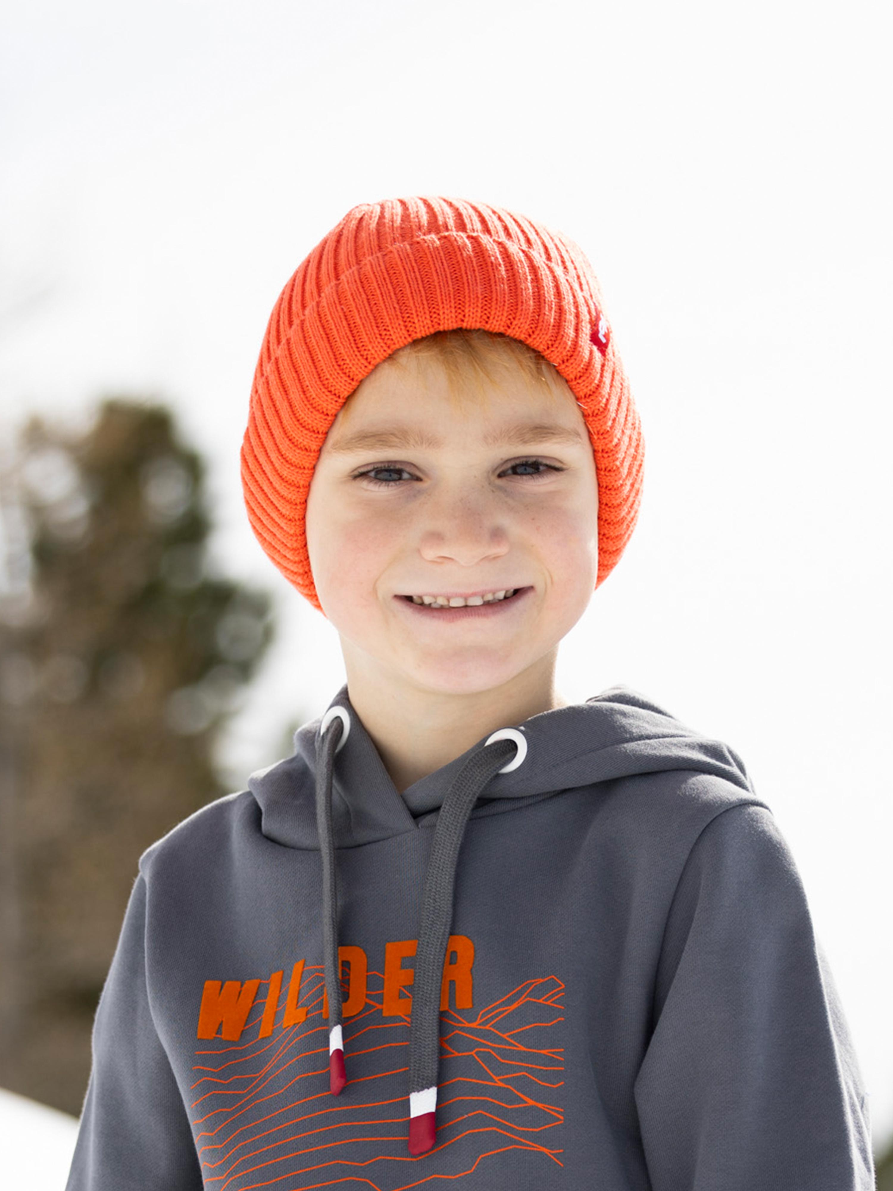 Ein Bub trägt die Kindermütze "Mika" in Lachs.