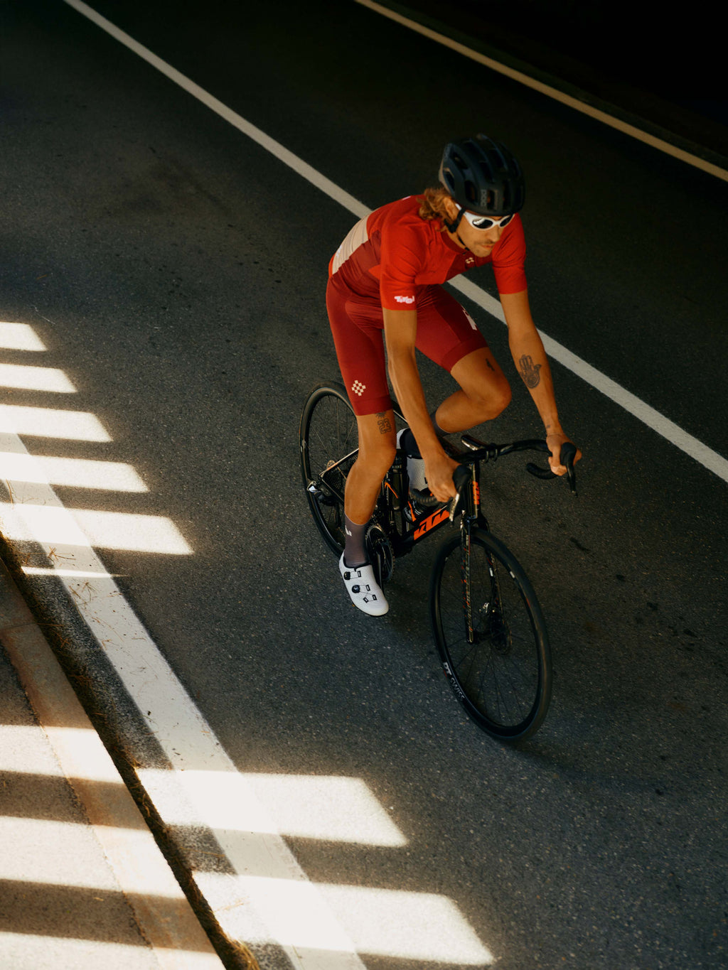 Ein Mann fährt auf einem Rennrad und trägt das Trikot "Kaunertal" in Rot