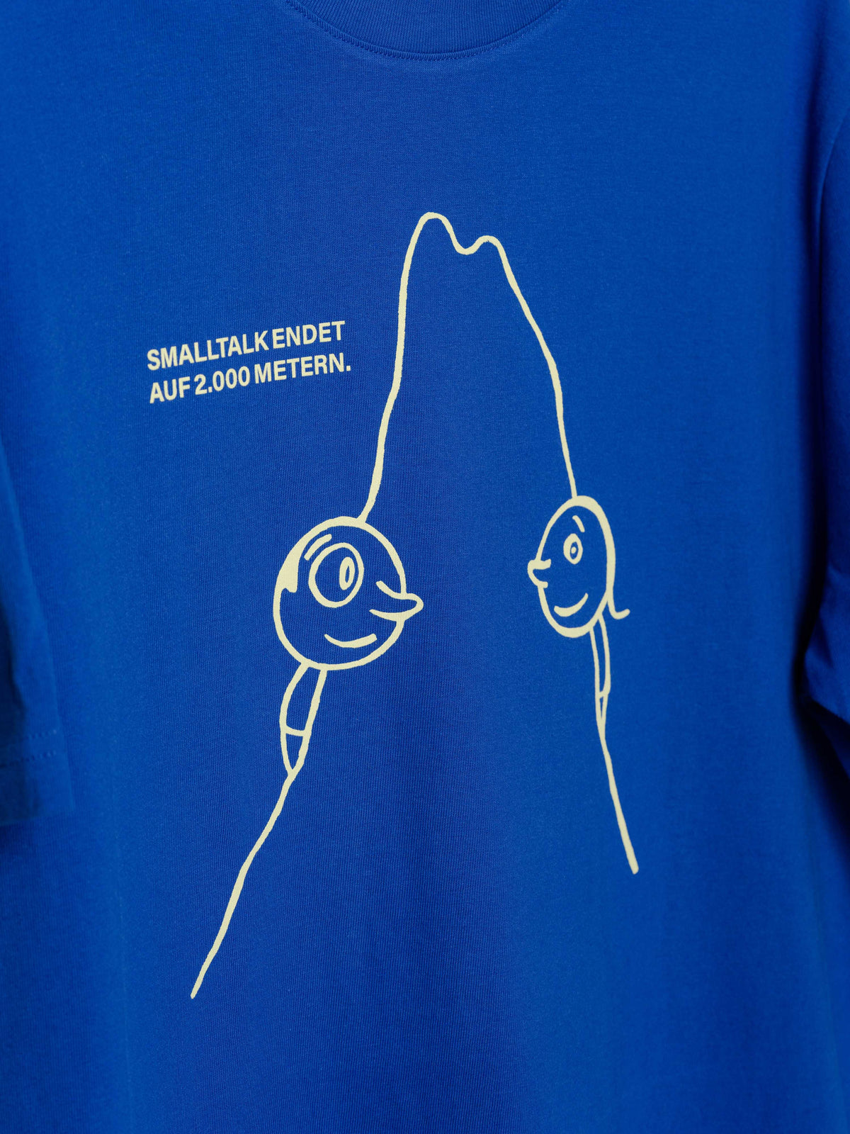 Unisex T-Shirt "Smalltalk" mit Line-Art-Print mit Schmunzelgesichter, Bergmotiv & Spruch „Smalltalk endet auf 2000 Metern.“ auf der Vorderseite. 