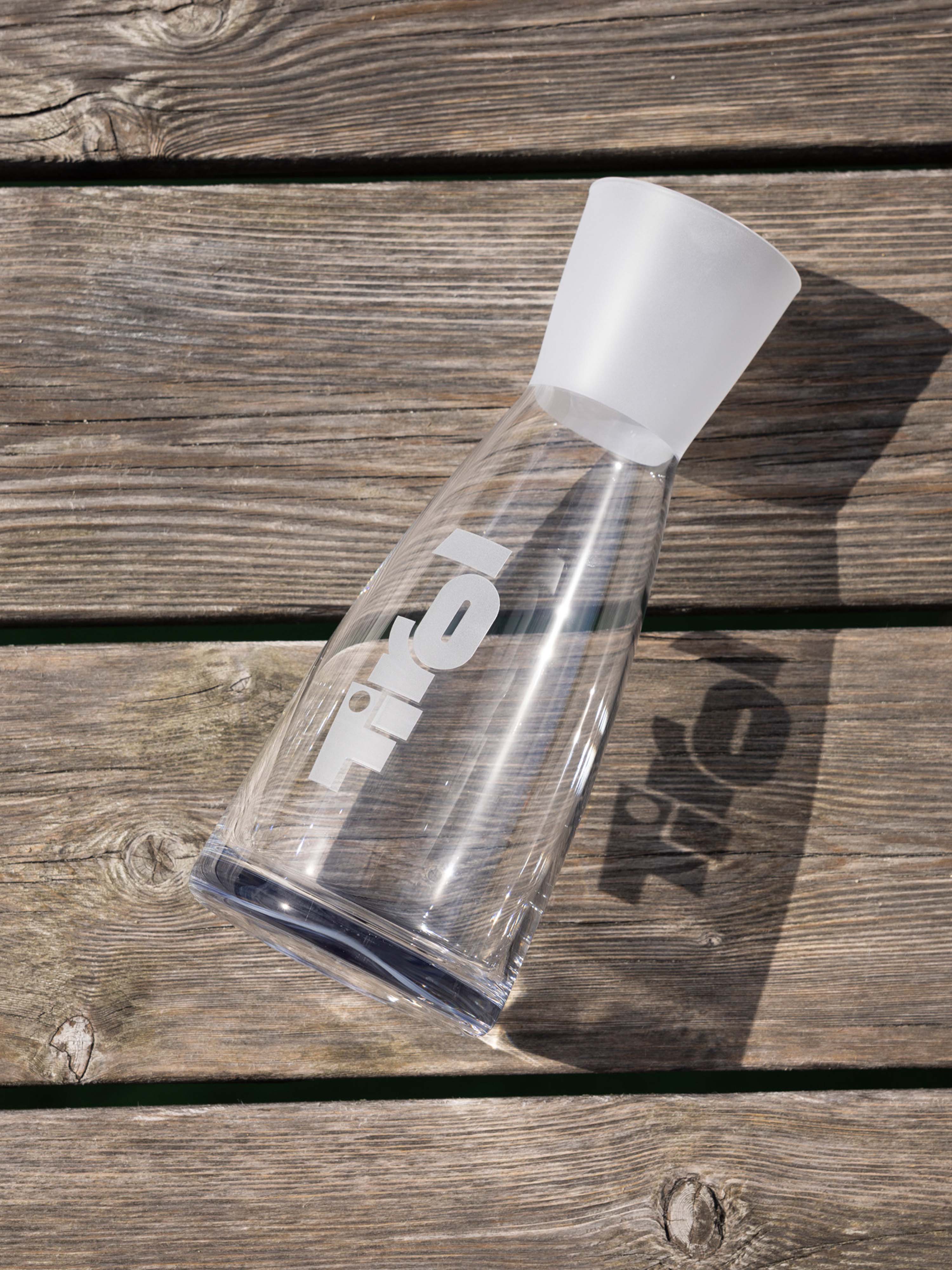 Die Wasserkaraffe "Trins" liegt auf einem grauen Holzboden